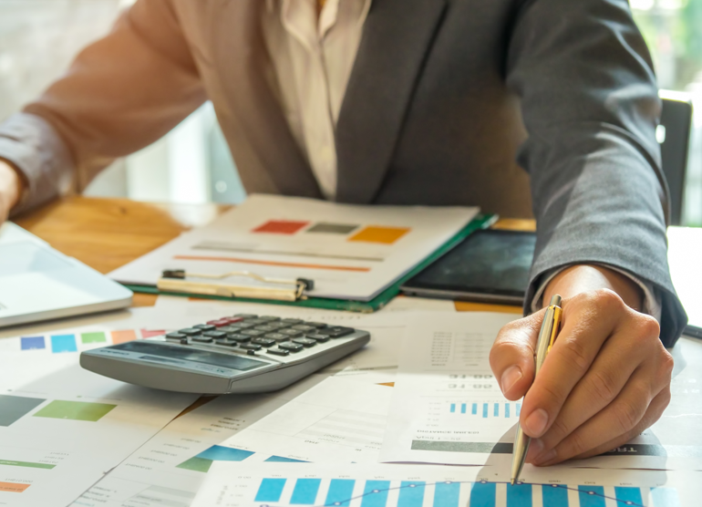 Consulting and Advisory Services 1 DTS Group advisor calculating and referencing graph on paper